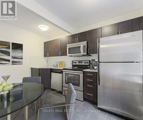 Toronto (Birchcliffe-Cliffside) condo for rent - A kitchen with a refrigerator, microwave, oven, and dining table.