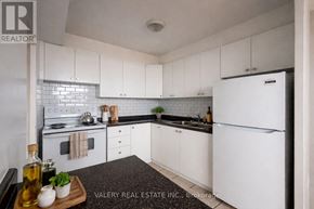 Toronto (Rockcliffe-Smythe) condo for rent - A kitchen with black and white appliances and cabinets.