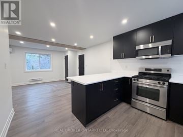Hamilton (Delta) apartment for rent - A modern kitchen with black cabinets and stainless steel appliances.