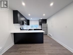 Hamilton (Delta) apartment for rent - A modern kitchen with black cabinets and a white countertop.