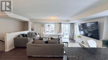 Ottawa townhouse for rent - A living room with a grey sofa and a television on the wall.