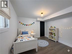 Hamilton apartment for rent - A bedroom with a white bed and a bookshelf with lights strung up.