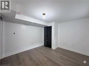 Hamilton apartment for rent - A room with a wooden floor and a black wardrobe.
