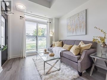 Toronto (Newtonbrook East) townhouse for rent - A modern living room with a grey couch and a glass coffee table.
