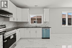 Windsor apartment for rent - A kitchen with white cabinets and a black counter top.