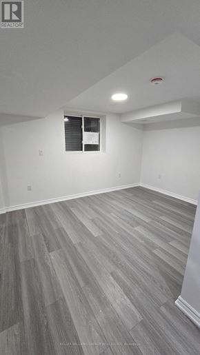 Clarington (Bowmanville) apartment for rent - A room with a window and a wooden floor.