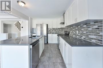 Ottawa apartment for rent - A modern kitchen with white cabinets and a stone backsplash.