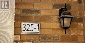 Milton (Cl Clarke) apartment for rent - A brick wall with a sign that says 325-1 and a lamp on it.