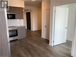 Kitchener condo for rent - A kitchen with a microwave, oven, and refrigerator.
