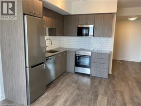 Kitchener condo for rent - A kitchen with a refrigerator, oven, and microwave.