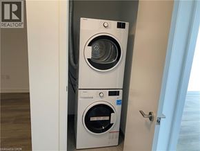Kitchener condo for rent - A white front loading washing machine in a laundry room.