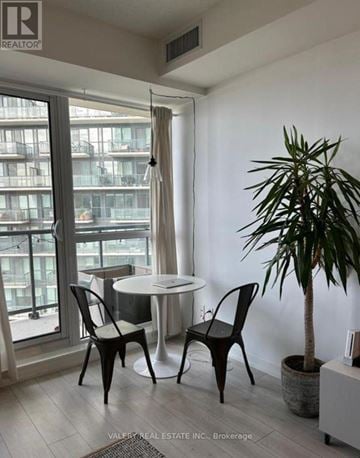 Toronto (Niagara) condo for rent - A living room with a table and chairs and a plant.