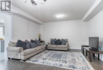 Halton Hills (Georgetown) apartment for rent - A living room with a grey couch and a blue rug.