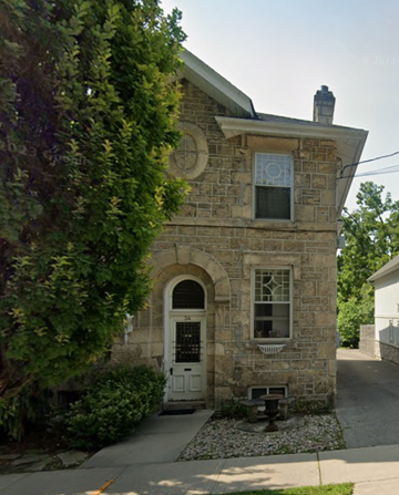 Guelph apartment for rent - A small stone house with a white door and window.