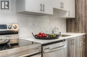 Kitchener condo for rent - A modern kitchen with stainless steel appliances and a marble countertop.