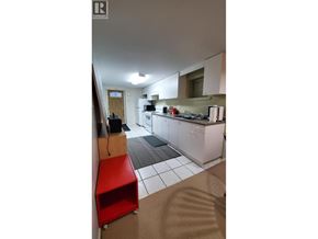 Vancouver apartment for rent - A kitchen with a red stool and white cabinets.