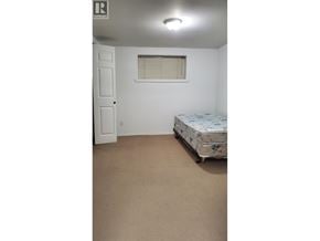 Vancouver apartment for rent - A bedroom with a bed, a door, and a window.