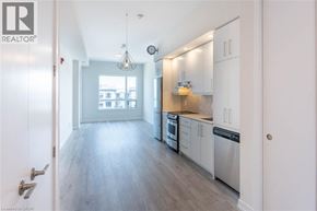 Grimsby condo for rent - A modern kitchen with white cabinets and stainless steel appliances.