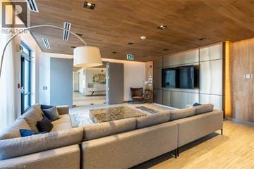 Grimsby condo for rent - A modern living room with a long couch and a television.