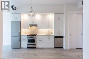 Grimsby condo for rent - A modern kitchen with white cabinets and stainless steel appliances.