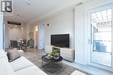 Grimsby (Grimsby Beach) condo for rent - A living room with a white couch and a black television.