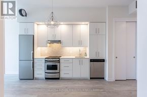 Grimsby (Grimsby Beach) condo for rent - A kitchen with white cabinets and a stainless steel refrigerator.