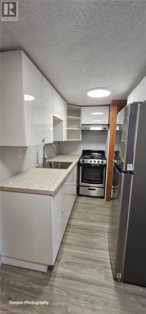 Kitchener apartment for rent - A kitchen with white cabinets and a wooden countertop.