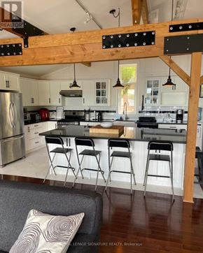 Gravenhurst (Muskoka (S)) apartment for rent - A kitchen with a refrigerator, stove, and bar stools.