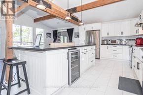 Gravenhurst (Muskoka (S)) apartment for rent - A kitchen with white cabinets and a black stool.