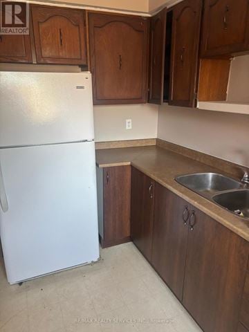 Brampton (Central Park) townhouse for rent - A white refrigerator in a kitchen with wooden cabinets.