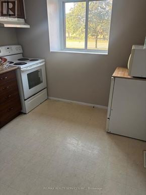 Brampton (Central Park) townhouse for rent - A small kitchen with a white stove and a white refrigerator.