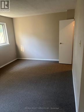 Brampton (Central Park) townhouse for rent - A room with a carpeted floor and a white door.