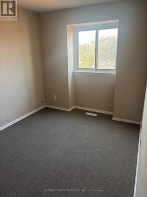 Brampton (Central Park) townhouse for rent - A room with a window and a grey carpet.