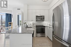 Toronto (Scarborough Village) condo for rent - A modern kitchen with stainless steel appliances and a granite countertop.