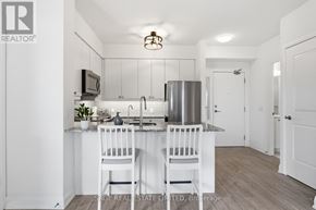 Toronto (Scarborough Village) condo for rent - A white kitchen with a sink and two chairs.