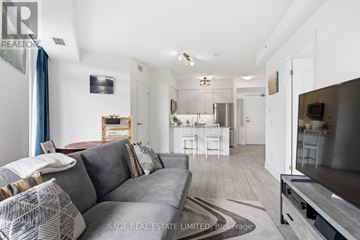 Toronto (Scarborough Village) condo for rent - A living room with a grey couch and a television.
