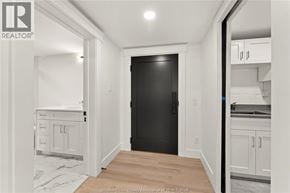 Amherstburg condo for rent - A black door is in the middle of a white room.