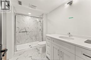 Amherstburg condo for rent - A bathroom with a marble tile shower and white fixtures.