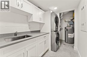 Amherstburg condo for rent - A clean, white kitchen with a washer and dryer in the laundry room.