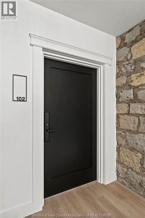 Amherstburg condo for rent - A black door with a white frame and a number 102 on the wall above it.