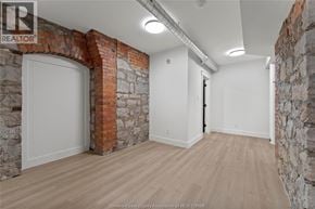 Amherstburg condo for rent - A room with a brick archway and wooden flooring.