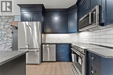 Amherstburg condo for rent - A kitchen with a stainless steel refrigerator and microwave.