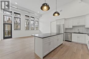Amherstburg condo for rent - A modern kitchen with white cabinets and a black countertop.