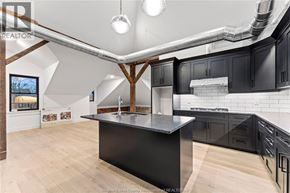 Amherstburg condo for rent - A kitchen with a black countertop and wooden cabinets.