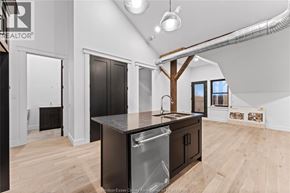 Amherstburg condo for rent - A modern kitchen with a large island and wooden floors.