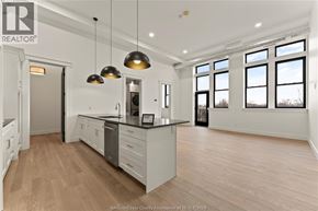 Amherstburg condo for rent - A well-lit kitchen with wooden floors and a large island.