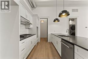 Amherstburg condo for rent - A modern kitchen with white cabinets and a wooden floor.