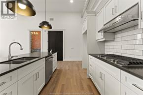 Amherstburg condo for rent - A kitchen with white cabinets and black countertops.