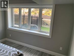 Cambridge apartment for rent - A bedroom with a large window and a bed with a patterned cover.