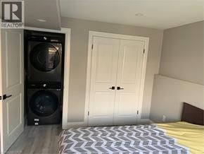 Cambridge apartment for rent - A bedroom with a bed, a washing machine, and a dryer in a small space.